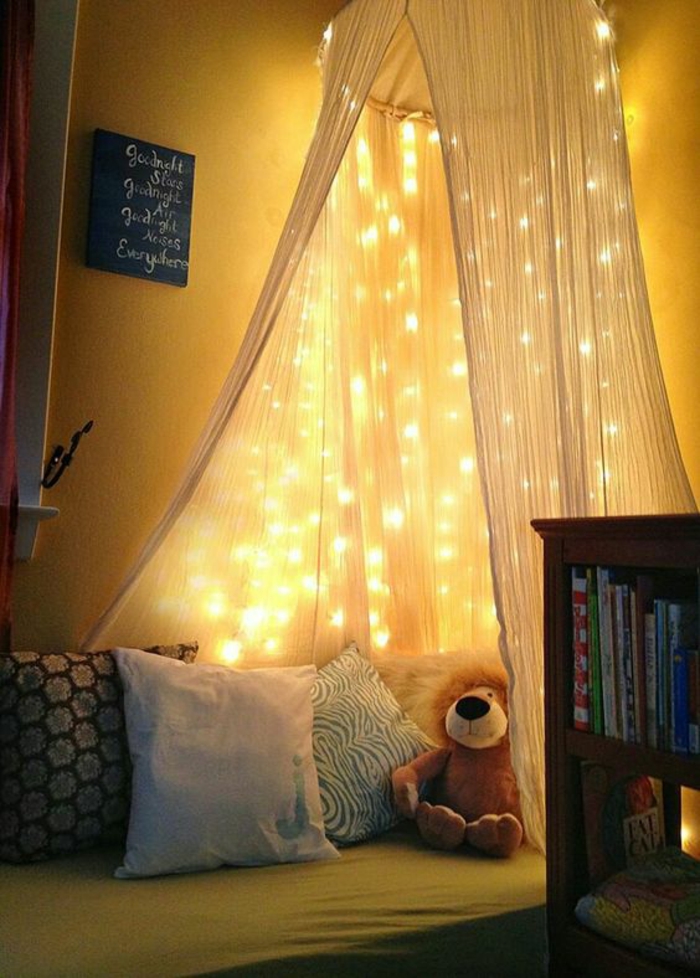 guirlande lumineuse boule, moustiquaire blanc transparent sur un lit de chambre d'enfant, guirlande lumineuse chambre, coussins et peluche sur le lit