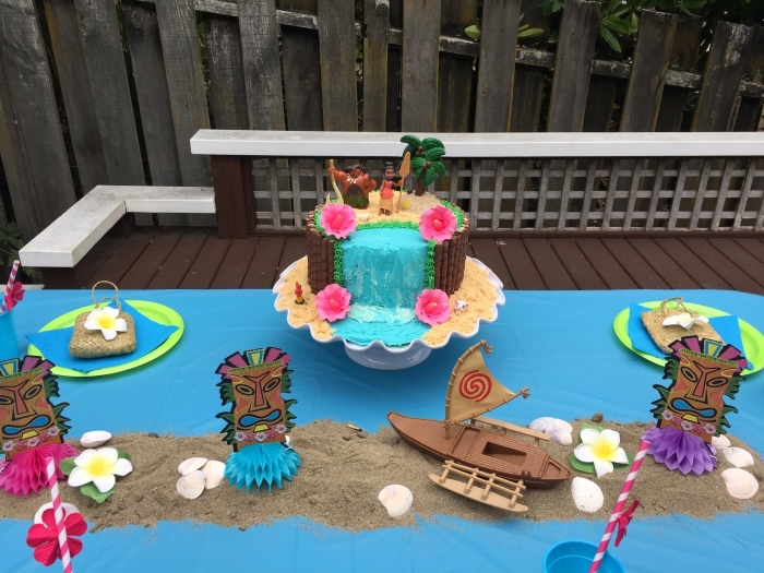 deco anniversaire vaiana avec un gâteau à design cascade d'eau et sable en biscuits avec petites fleurs en pâte à sucre