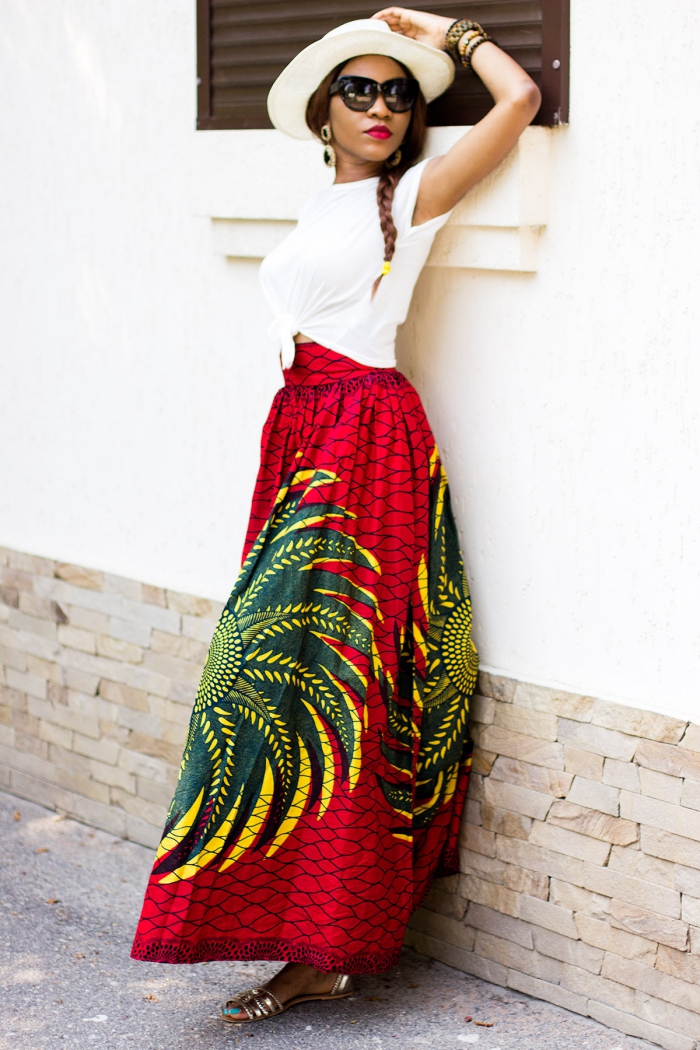 vision bohème et romantique avec une jupe maxi en tissu africain haut en couleurs, combinée avec un simple t-shirt blanc et un chapeau blanc à large bord