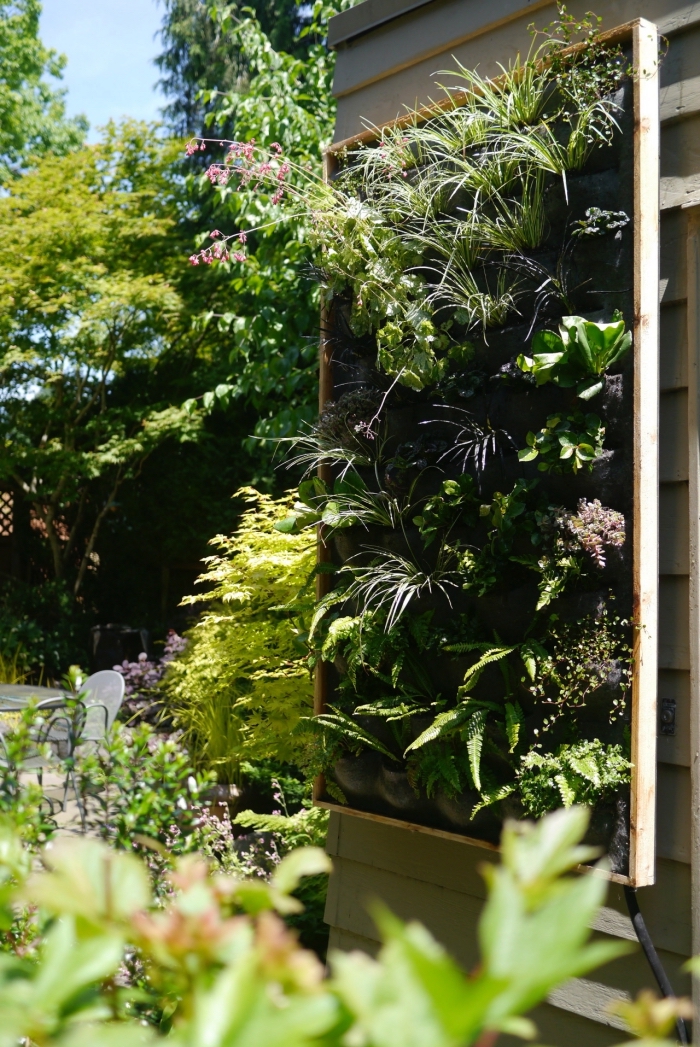 système de mur vegetal exterieur avec une structure en bois, des poches de feutre horticole et un système d'arrosage automatique