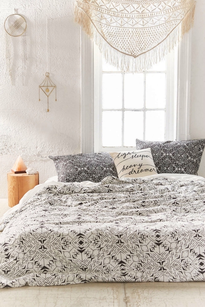 exemple de decoration boheme dans une pièce blanche avec lit au sol couvert de housse blanc et noir, diy macramé comme cantonnière fenêtre