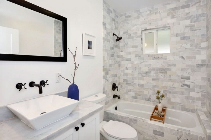 idée comment aménager une petite salle de bain blanche au carrelage baignoire gris et blanc avec miroir et robinets en noir