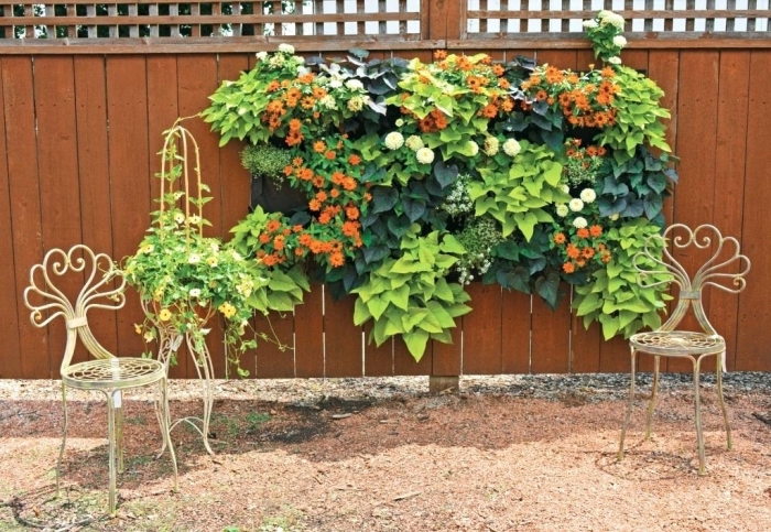 idée originale pour une décoration murale d'extérieur avec un mur végétal en tissu feutré avec des poches pour plantes