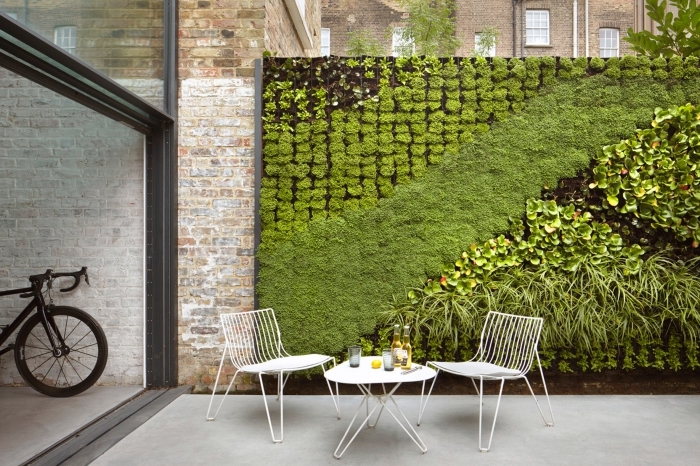 un mur vegetal exterieur qui crée un joli contraste avec l'ambiance industrielle du patio 