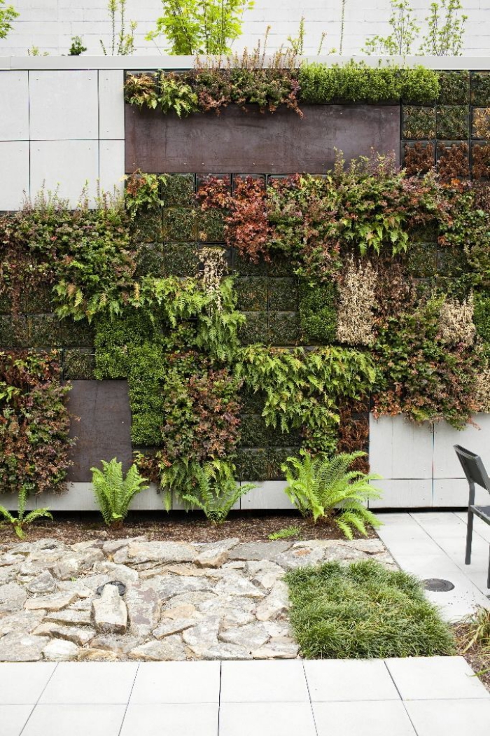 idée déco murale originale pour le patio ou le jardin, un mur vegetal exterieur en sphaigne du chili, avec des plantes de couleur et de texture différente