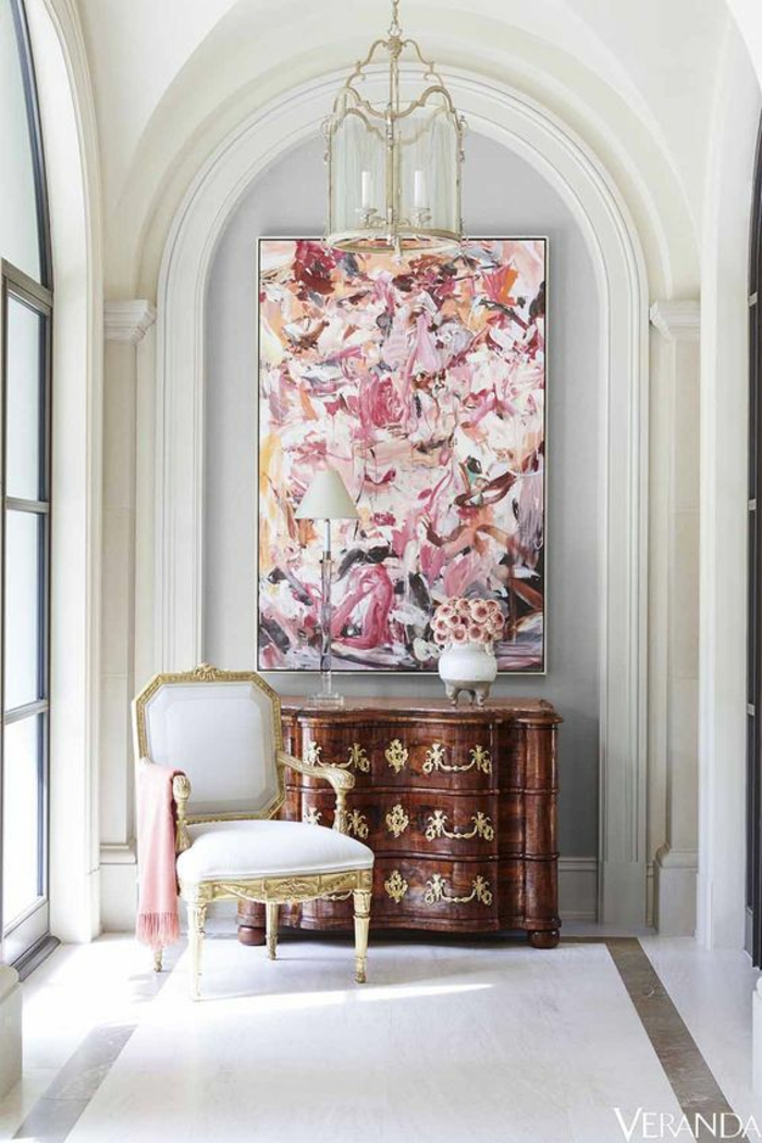 chambre rose poudré et taupe, grand tableau rectangulaire en style art abstrait, luminaire en verre et en métal doré, carrelage blanc aux effets marbrés, fauteuil en tissu blanc et en style baroque