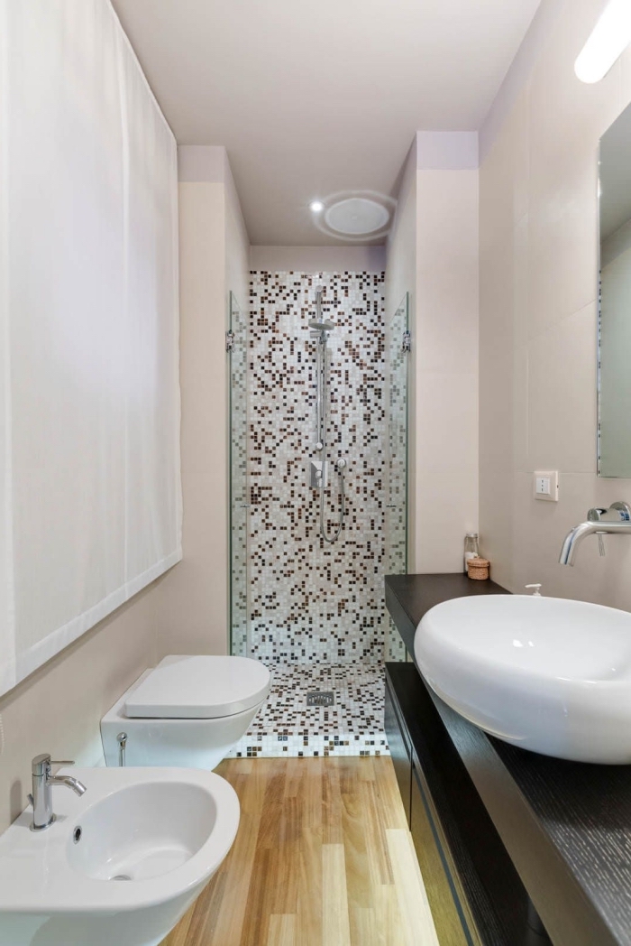 modèle salle de bain en longueur avec petite cabine de douche en carrelage mosaïque et revêtement plancher en bois