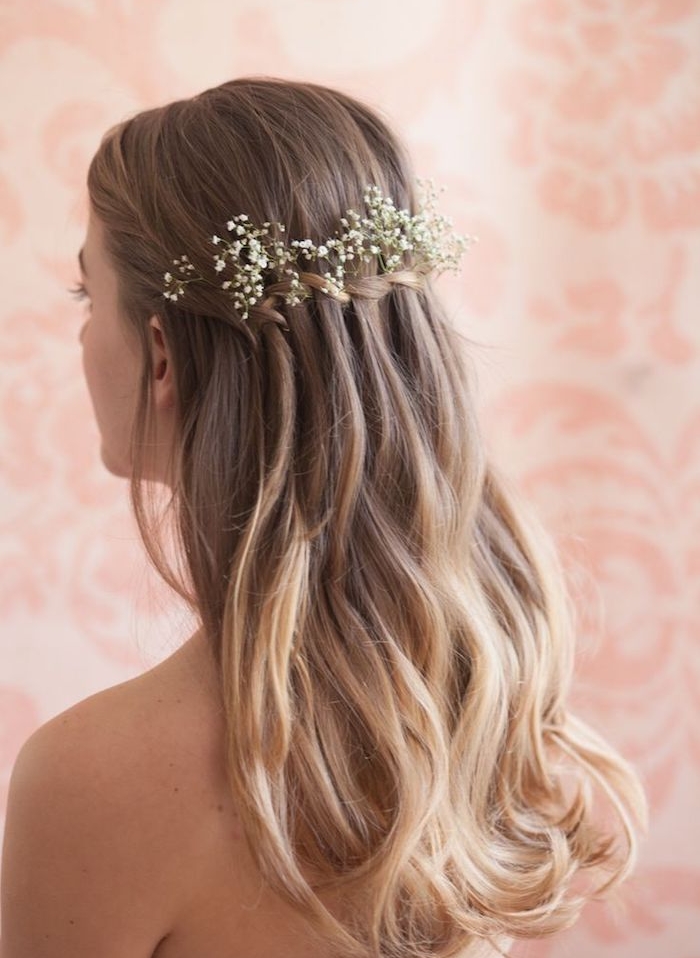exemple-de-tresse-cascade-avec-de-petites-fleurs-blanches-et-ondulations-légères-cheveux-longs-blond exemple de tresse en cascade femme, avec une décoration de fleurs fraîches blanches, cheveux ondulés