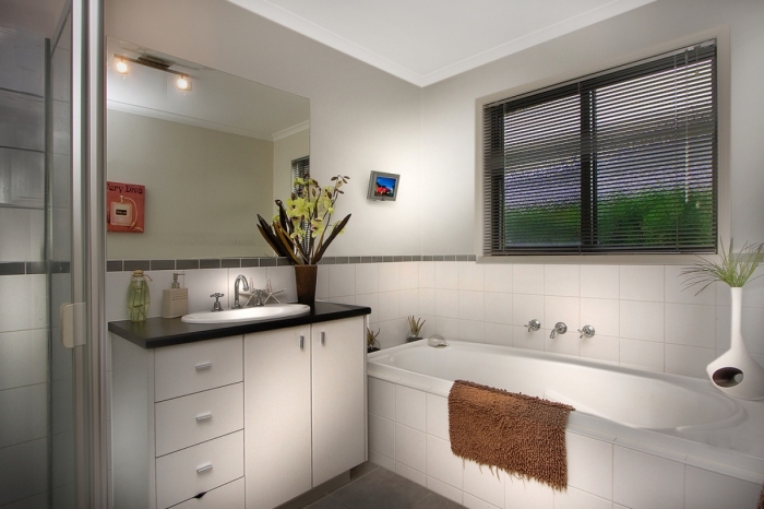 idée amenagement salle de bain petit espace aux murs gris clair avec carrelage en blanc, déco salle de bain douche et baignoire