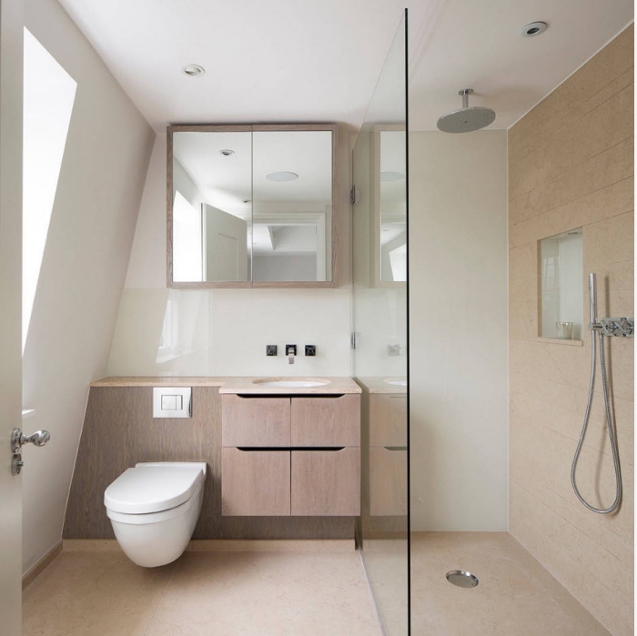 modèle de salle de bain mansardée au plafond blanc avec cabine de douche en carrelage beige et meuble fonctionnel beige