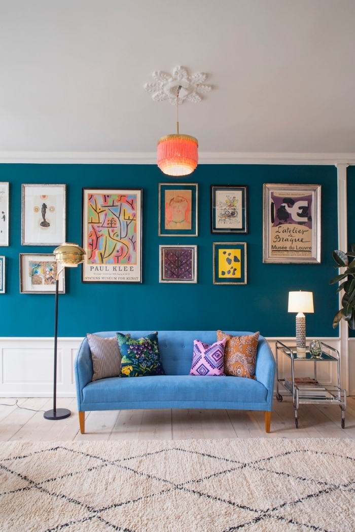 mur bleu canard sublimé par une galerie photos aux tons gais et un canapé d'une nuance de bleu turquoise