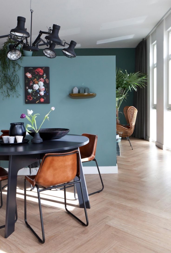 utilisation de différentes tonalités de la peinture bleu pétrole permet de séparer visuellement les deux espaces distincts du salon et de la salle à manger
