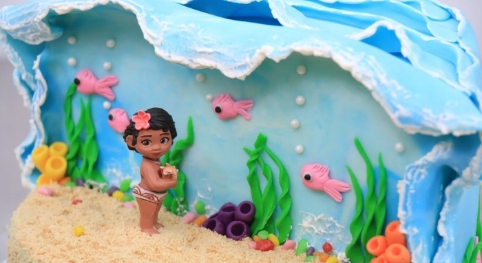 magnifique exemple de gâteau fait maison sur le thème Disney, modèle gâteau à design océan et sable avec figurine bébé vaiana