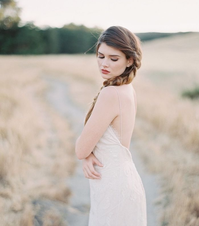 grande-tresse-sur-le-coté-cheveux-longs-denses-robe-de-mariée-légère-avec-des-bretelles-fines-cheveux-chatain comment faire une tresse sur le coté, cheveux chatain longs, robe de mariée dentelle simple