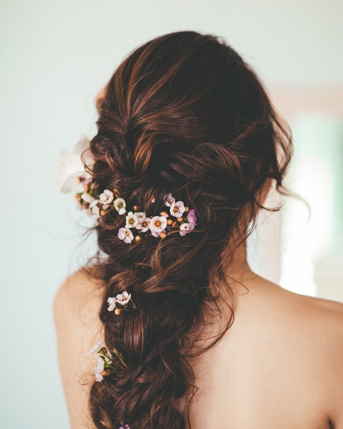 grosse-tresse-en-arrière-style-princesseprincesse-décoiffé-fleurs-champetres-dans-les-chevux-coiffure-romantique tresse volumineuse femme avec décoration de petites fleurs, mèches libres, style décoiffé bohème
