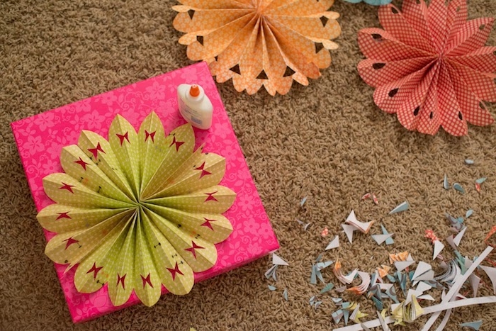 comment décorer un emballage cadeau avec un éventail en papier perforé à motif papillon, une sorte de fleur decorative en papier