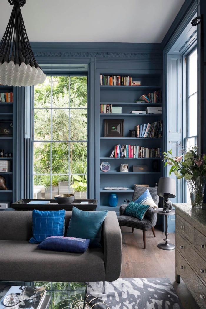 salon bleu et gris avec mur bibliothèque et encadrement peints en bleu marine pour structurer l'espace et lui donner de la profondeur