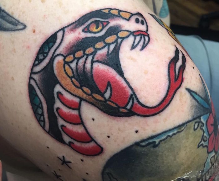 tatouage femme epaule discret tete de serpent noir rouge jaune style old school