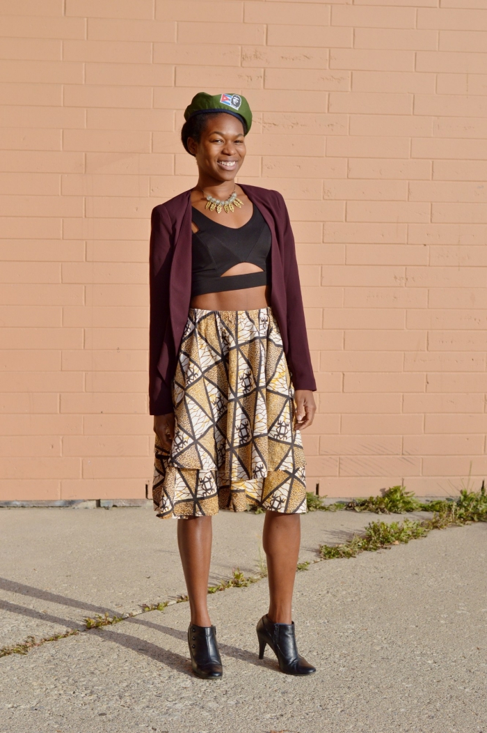 look urbain chic qui combine avec succès la mode militaire et le motif africain, une jupe midi évasée en imprimé wax assortie avec un crop top noir découpé