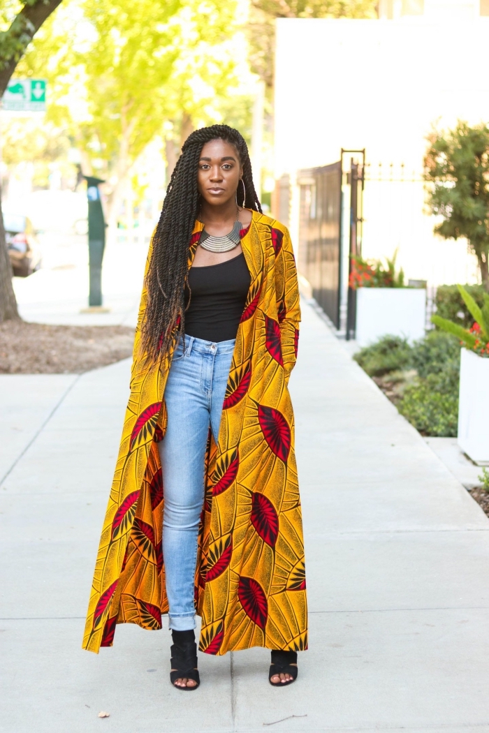 manteau long en tissu africain à motif feuilles sur fond jaune ocre qui fait réveiller le look en jean et en top noir 