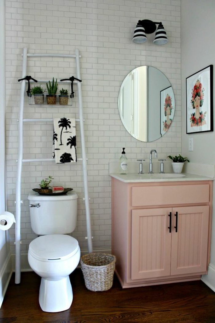 salle de bains rose poudree, carrelage mural blanc aux motifs briques blanches, tableau mural avec portrait de femme hyper coloré, meuble en couleur rose poudré
