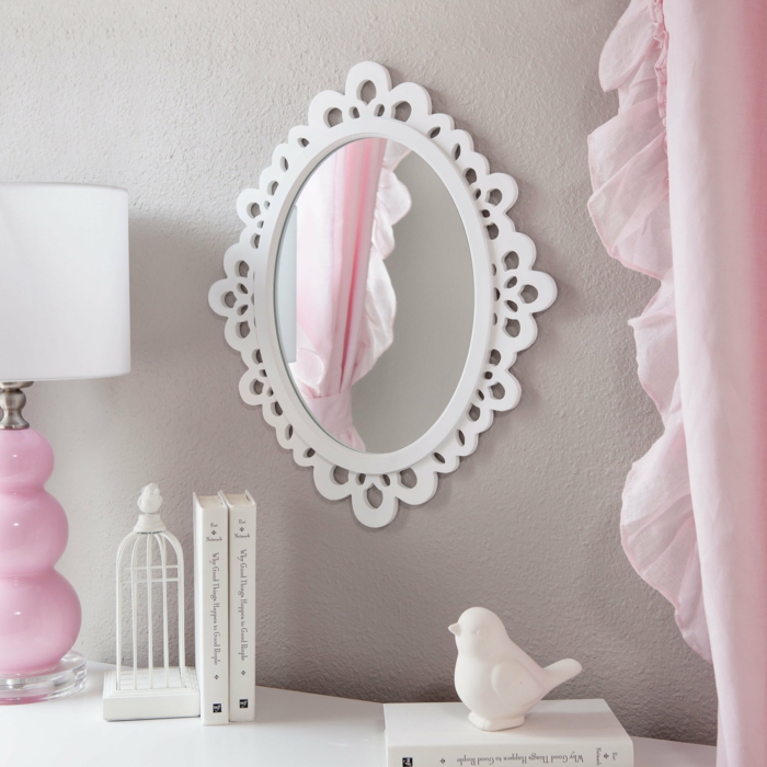 rideau volanté en couleur rose poudré et lampadaire avec base en céramique en couleur rose pale, mur taupe, petite cage décorative en céramique blanche sur le meuble blanc