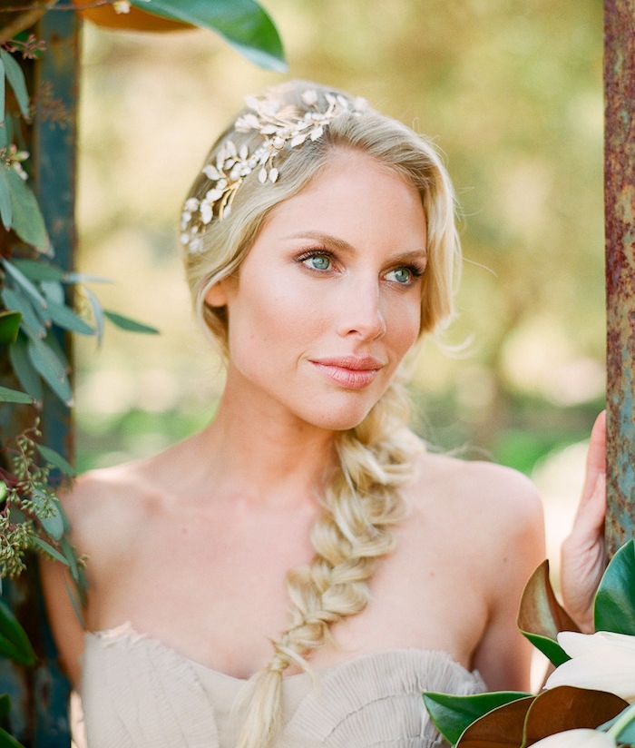 modèle-original-de-coiffure-mariee-avec-une-tresse-de-côté-et-un-accessoire-cheveux-blanc-robe-de-mariée-beige exemple de tresse desserrée et accessoire cheveux couronne de branches artificielles
