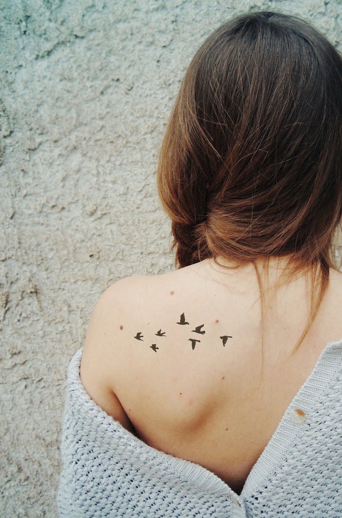 tatouage vol d'oiseaux discret noir sur l'épaule omoplate femme