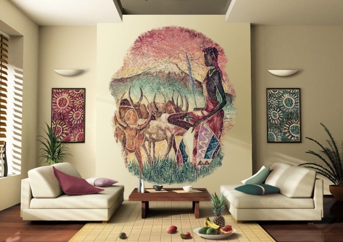 esprit africain dans un salon beige aménagé avec canapés bas et table basse de bois foncé, déco murale avec peinture paysage africain