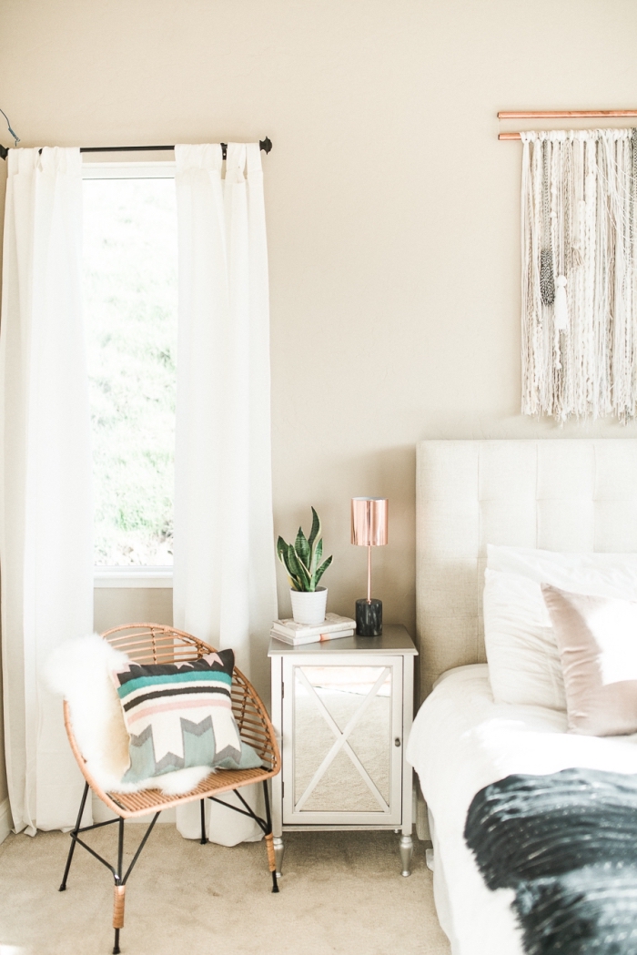 design intérieur moderne dans une chambre à coucher beige aménagée de style bohèle avec grand lit à tête boutonnée blanche et diy macramé