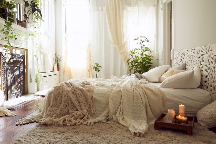 deco boheme chic dans une chambre blanche avec cheminée et grande fenêtre, déco de lit au sol avec têt ede lit blanche aux motifs mandala