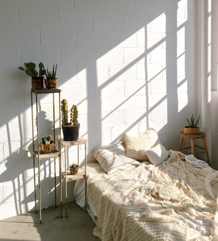 modèle de pièce aménagée en style minimaliste et bohème chic avec un lit et petite table de chevet en bois