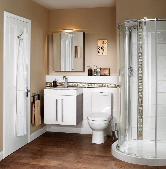 amenagement salle de bain petit espace aux murs beige avec plancher marron et équipement cuvette lavabo et cabine de douche en blanc