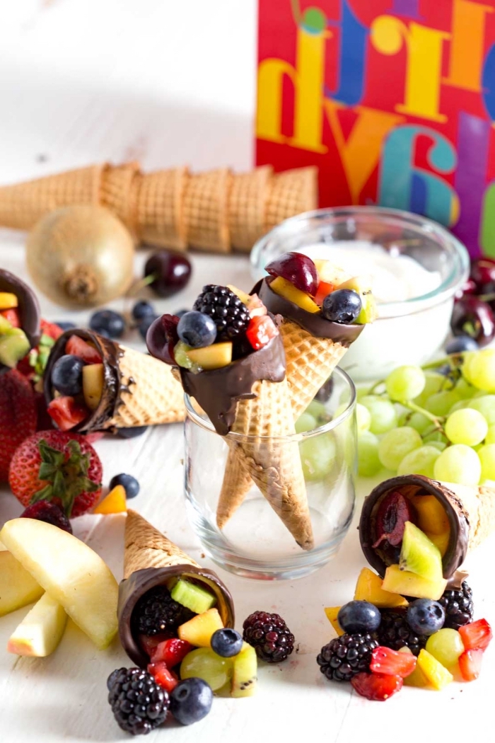 des cornets de glace chocolat et vanille remplis de salade de fruits frais, parfaits pour un brunch ou un buffet d'anniversaire