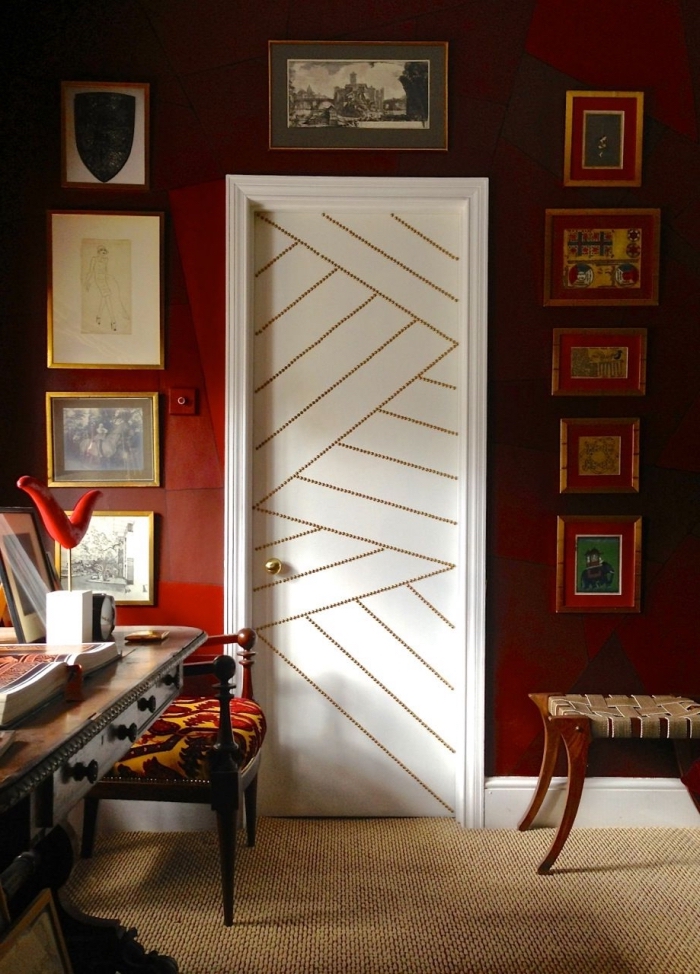 une porte blanche décorée de clous tapissier, recouvrir porte interieure de clous tapissier