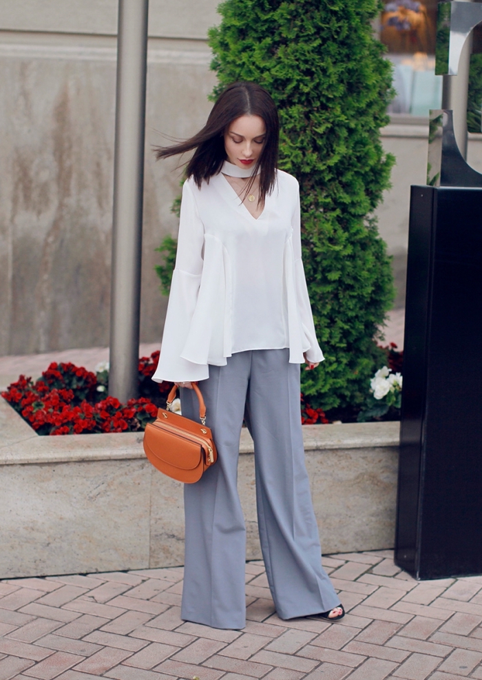 modèle de pantalon fluide femme habillé en gris clair avec blouse loose en blanc, modèle de sac à main de cuir marron
