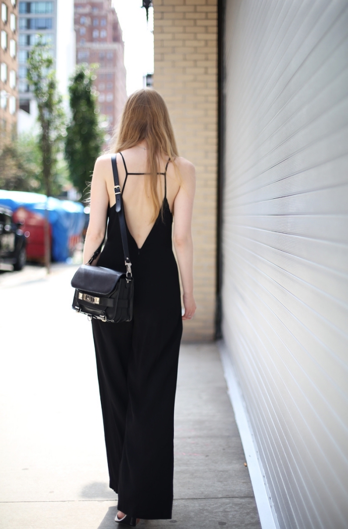exemple de combinaison pantalon femme de couleur noire à dos nu et design fluide combinés avec sac à main noir