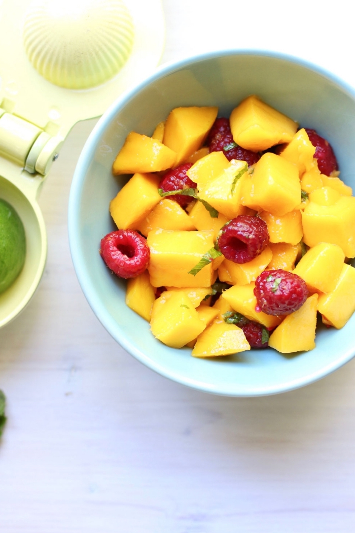 savourez la fraîcheur de la saison estivale avec une salade composée de mangue, framboises, parfumé à la menthe, avec jus de citron