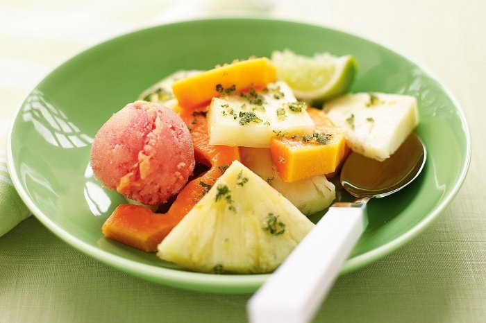recette salade de fruits simple et rafraîchissante de papaye et d'ananas, avec jus de citron et menthe, accompagnée de boules de sorbet