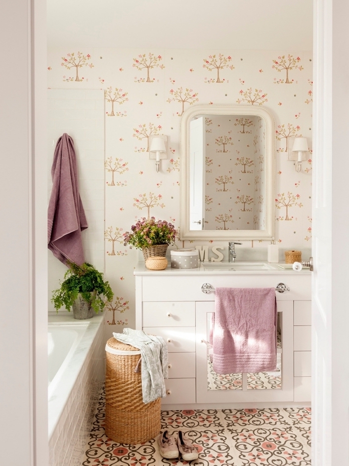les carreaux de ciment et le papier peint champêtre derrière le lavabo apportent une ambiance douce et romantique dans cette petite salle de bains