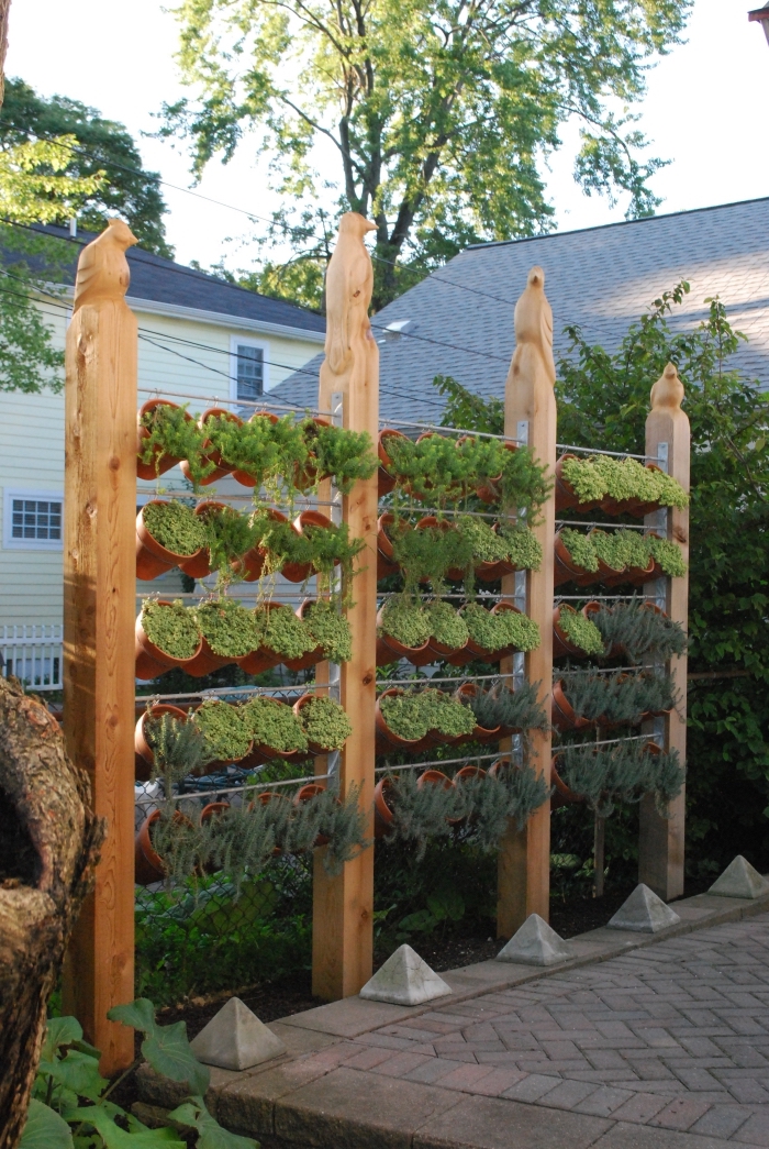 un mur végétal extérieur facile à entretenir, composé de pots suspendus sur un support de cadre en bois et grillage, aménagement petit jardin de ville