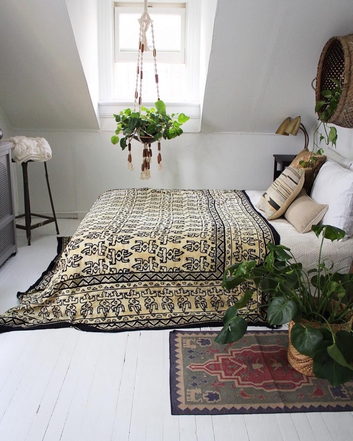 idée comment aménager une pièce aux combles de style bohème chic, chambre à coucher avec grand lit et plantes vertes