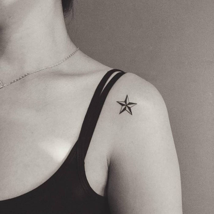 tatouage discret d'étoile nautique noir et blanc sur une épaule de femme