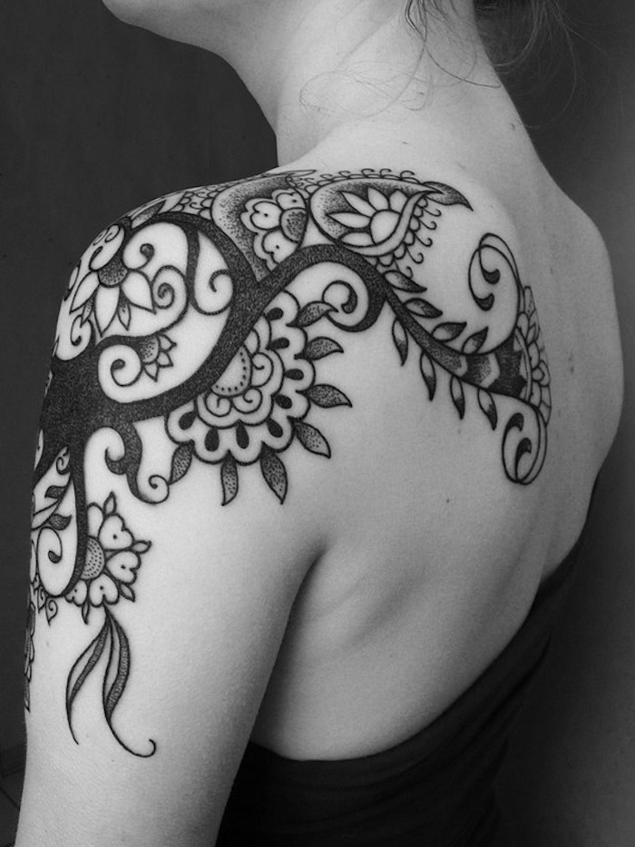 tatouage femme epaule fleurs style mandala noir blanc qui déborde sur l'omoplate et le bras