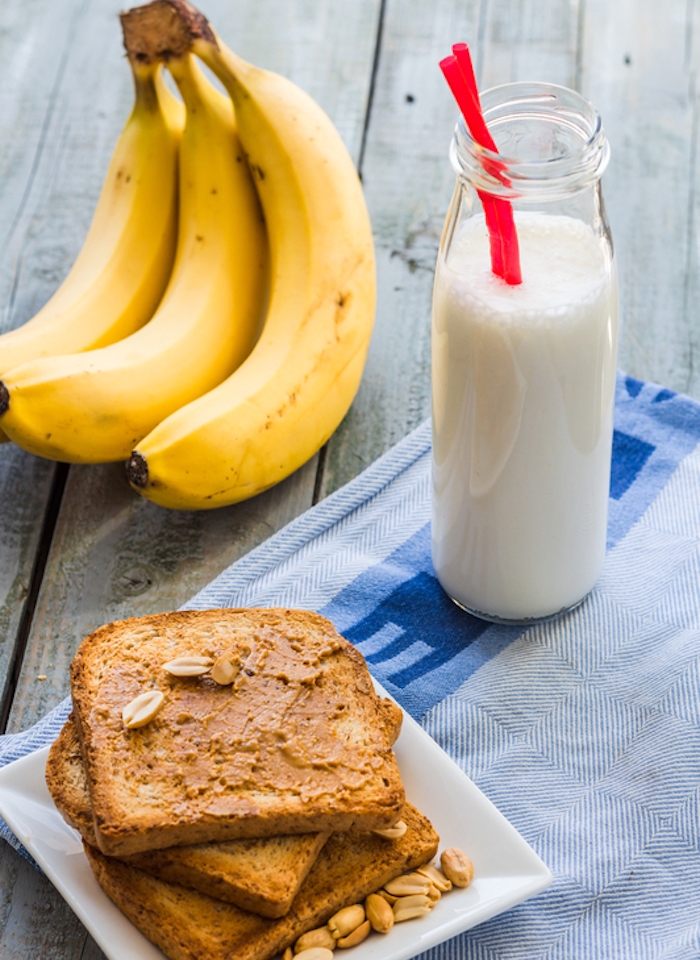 toast tartiné de beurre d arachide avec des cacahuètes et un petit pot en verre rempli de lait, bananes