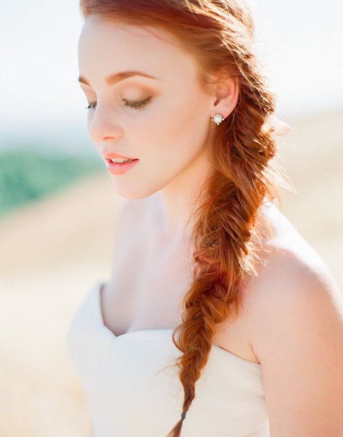 tresse-en-épi-de-coté-sur-des-cheveux-rux-longs-et-lisses-robe-de-mariée-blanche-teinte-de-peau-blanche tresse de coté cheveux roux longs, idée de coiffure bohème chic, style décoiffé mariée, coiffure mariage avec tresse