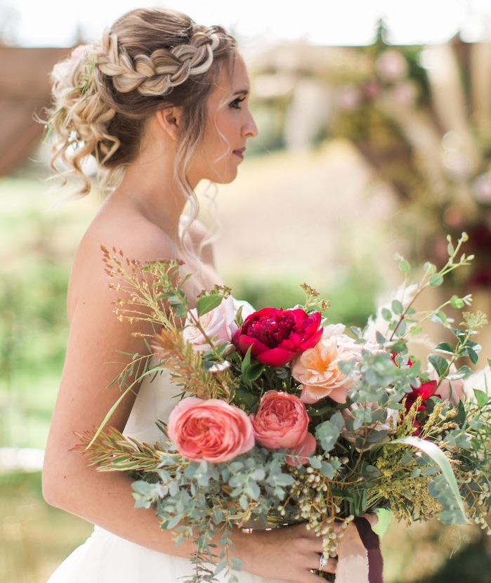 tresse-laterale-de-coté-volume-sur-le-dessus-cheveux-ramassés-en-arrière-avec-des-ondulations-romantiques tresse sur le coté qui va en arrière de la tete, cheveux attachés ondués blond foncé avec des mèches blonds claires balayage, bouquet de mariee champetre