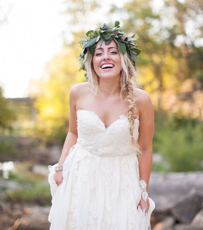 tresse-sur-le-coté-et-des-mèches-de-cheveux-libres-accessoirisés-d-une-couronne-de-fleurs-robe-de-mariée-bohème-chic couronne de fleurs sur uen coiffure mariage boheme chic, sur le coté avec meches blondes libres, robe de mariée déesse