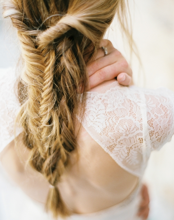 vue-d-arrière-une-tresse-en-épi-sur-tresse-africaine-avec-des-mèches-libres-robe-de-mariée-dentelle-dos-nu tresse epi sur tresses africaines en arrière de la tête, robe avec des manches en dentelle
