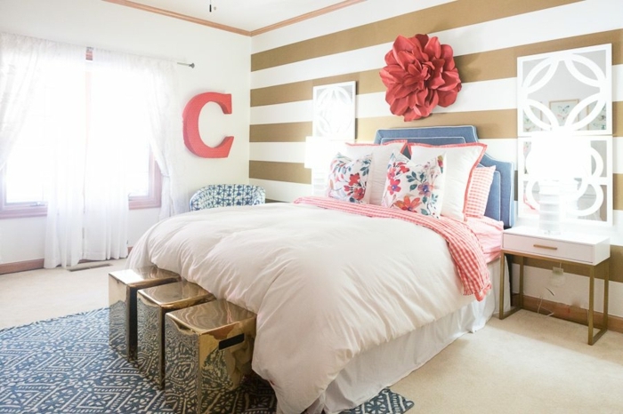 peinture chambre adulte originale, literie rose, tete de lit rose, grande fleur au mur, rideaux blancs, tapis bleu 